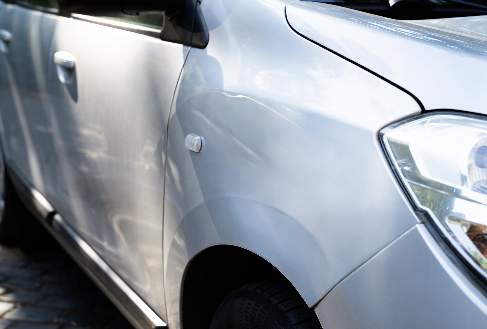 Before: severe hail damage on a Denver vehicle hood